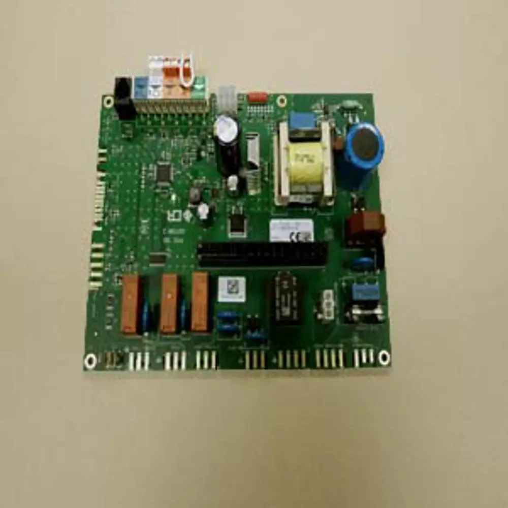 Remeha Steuerplatine mit verschiedenen elektrischen Komponenten. Sichtbare Relais, Kondensatoren und Sicherungen auf grünem Leiterplattendesign.